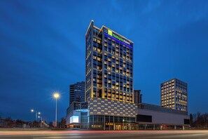 A Holiday Inn Express hotel with a modern design, featuring a prominent glass facade and a rooftop terrace. - Holiday Inn Express Qinhuangdao Haigang By IHG (Qinhuangdao)