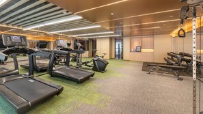 Ett gym med löpband, crosstrainers och utrustning för styrketräning.