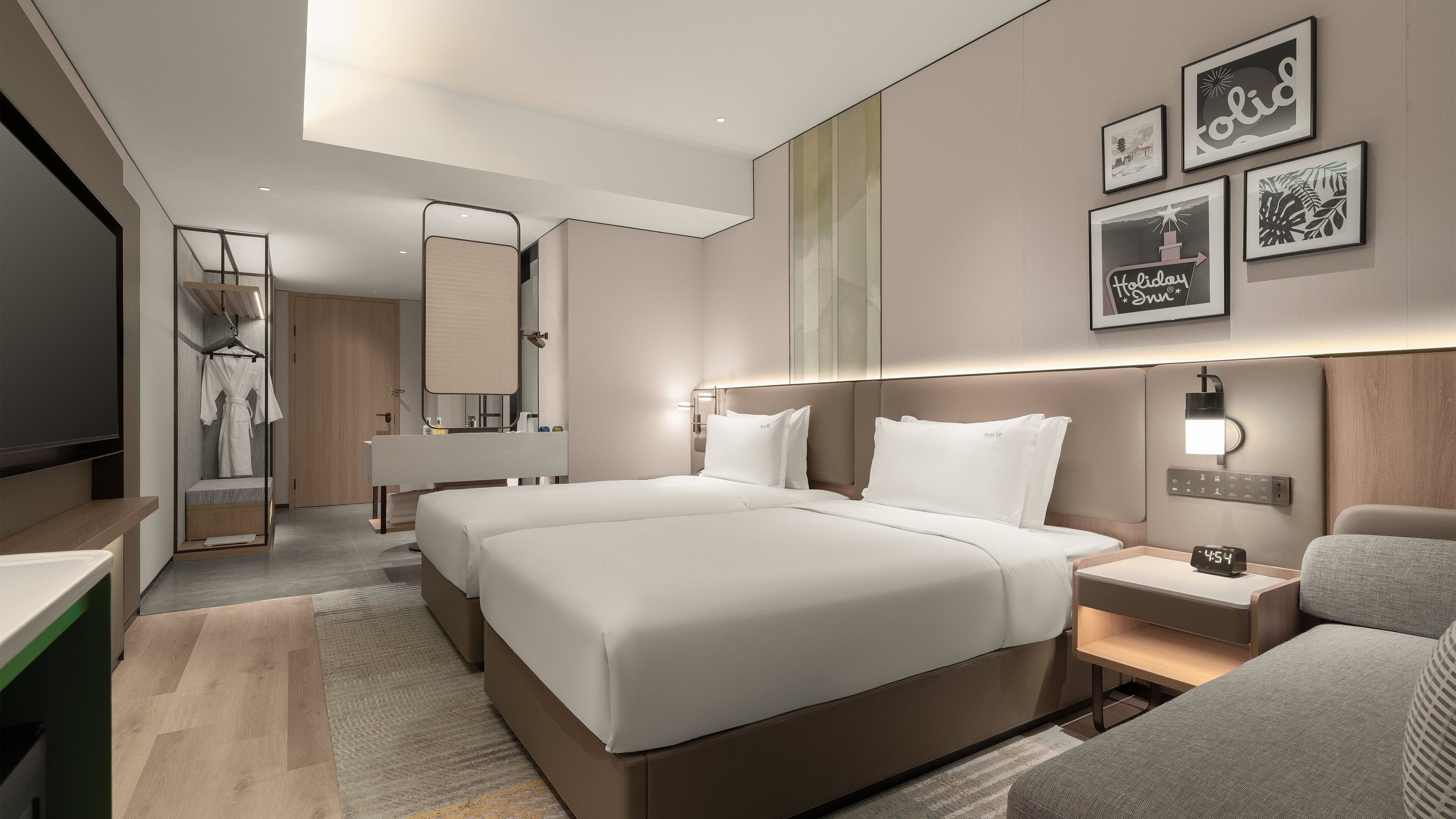 A modern hotel room with a large bed, bedside tables, a TV, and a mirror.