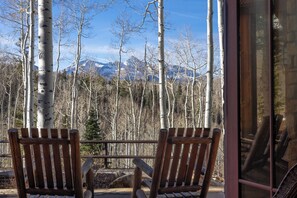 Two wooden Adirondack chairs facing a mountain view with birch trees in the foreground. - Luxurious 5-bedroom house in Mountain Village ideal for your getaway, any season (Mountain Village)