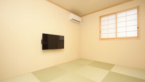 A room with tatami flooring, a mounted TV, and a sliding shoji screen window. - Hitoyoshi Onsen Oga no Yado (Hitoyoshi)