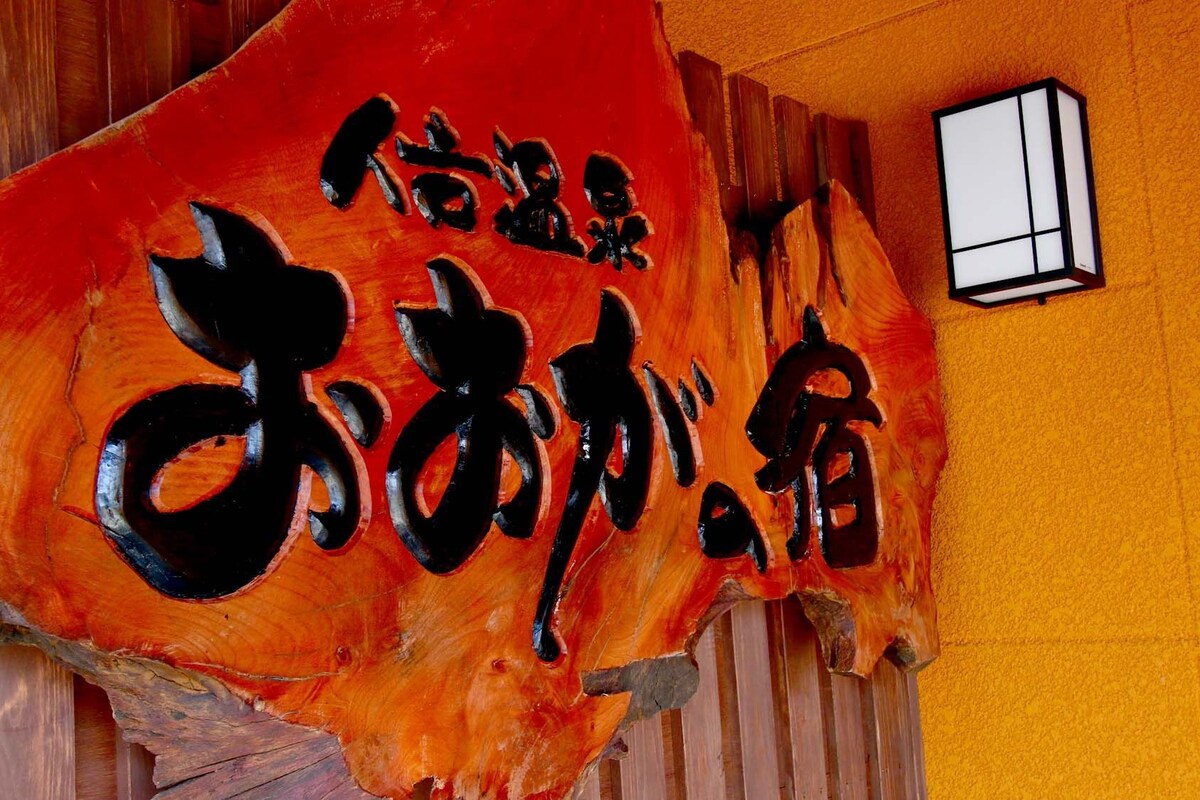 Pared de madera con un letrero grande, tallado y con caracteres japoneses.