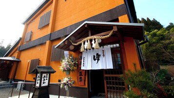 Um edifício tradicional japonês, com entrada de madeira e uma placa com caracteres japoneses.