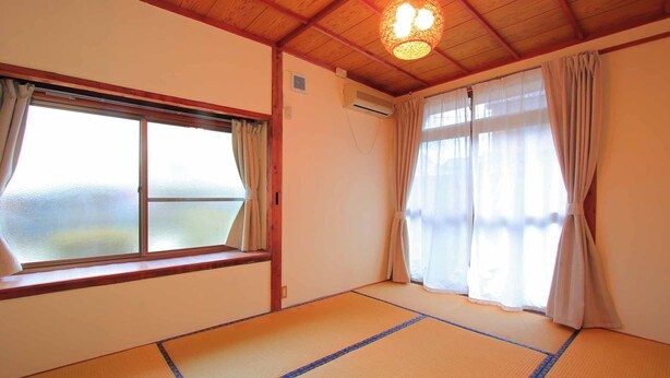 A room with tatami flooring, a large window with curtains, and a ceiling light fixture. - Hitoyoshi Onsen Oga no Yado (Hitoyoshi)