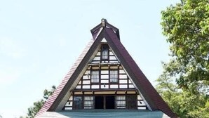Una casa de madera tradicional con un techo pronunciado y un amplio porche.