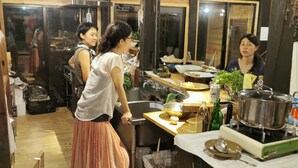 Una cocina con paredes de madera, una estufa y varios utensilios de cocina.