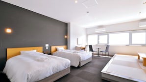 Een moderne hotelkamer met twee bedden, een bureau en een stoel.