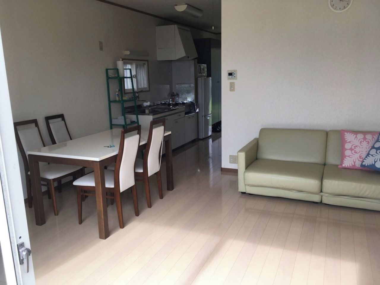 A compact living space with a dining area, kitchenette, and a sofa.