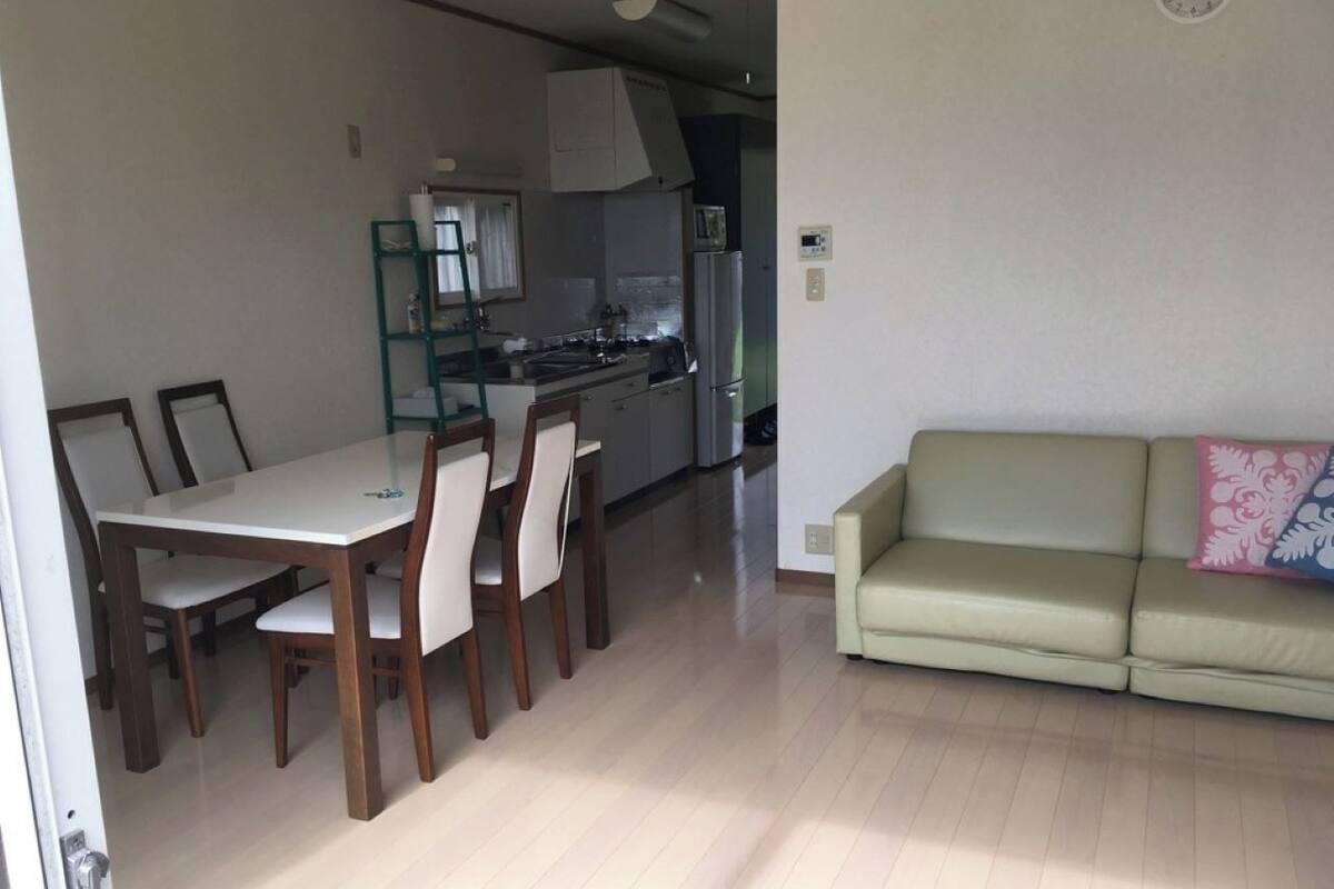 A compact living space with a dining area, kitchenette, and a sofa.