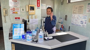 Un comptoir d’accueil équipé d’un téléphone, d’un ordinateur et de divers produits d’hygiène.