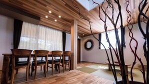 A dining area with wooden furniture and a potted plant. - Kawaguchiko Villa FJ Resort (Fujikawaguchiko)
