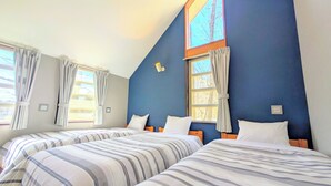 A bedroom with two beds, a sloped ceiling, and windows with curtains. - Nasu Kogen Rental Cottage Yellow Base (Nasushiobara)