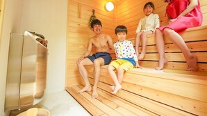 A sauna room with wooden benches, a visible heater, and a metallic cabinet. - Nasu Kogen Rental Cottage Yellow Base (Nasushiobara)