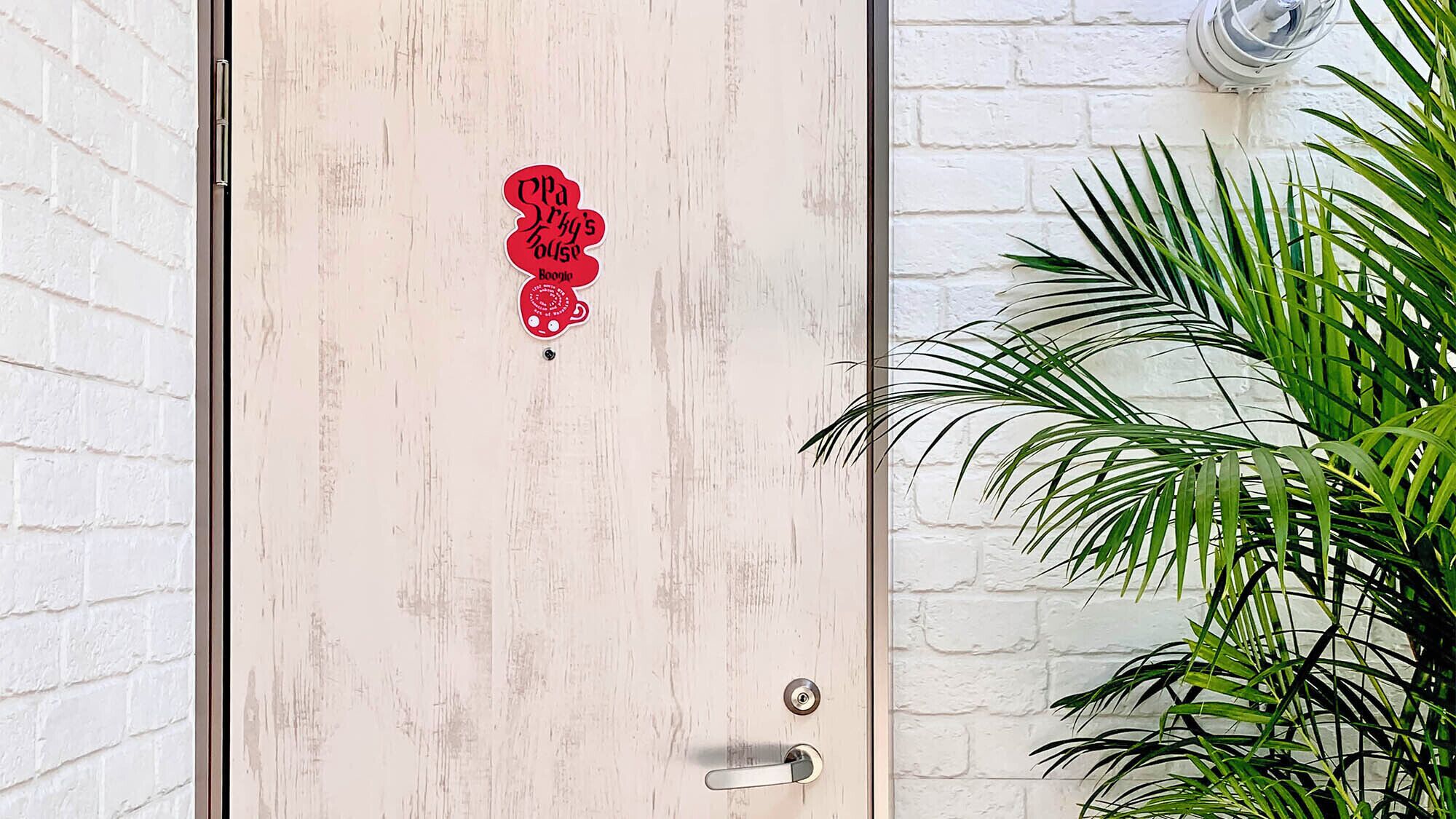 A wooden door with a red sticker that reads "Old Spice Boogie."
