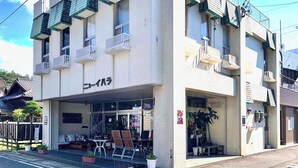 A building with a sign reading "Nyu-Ibara" and a coffee shop sign "Spalding's Coffee" inside. - Sparky's House / House II (Naoshima)