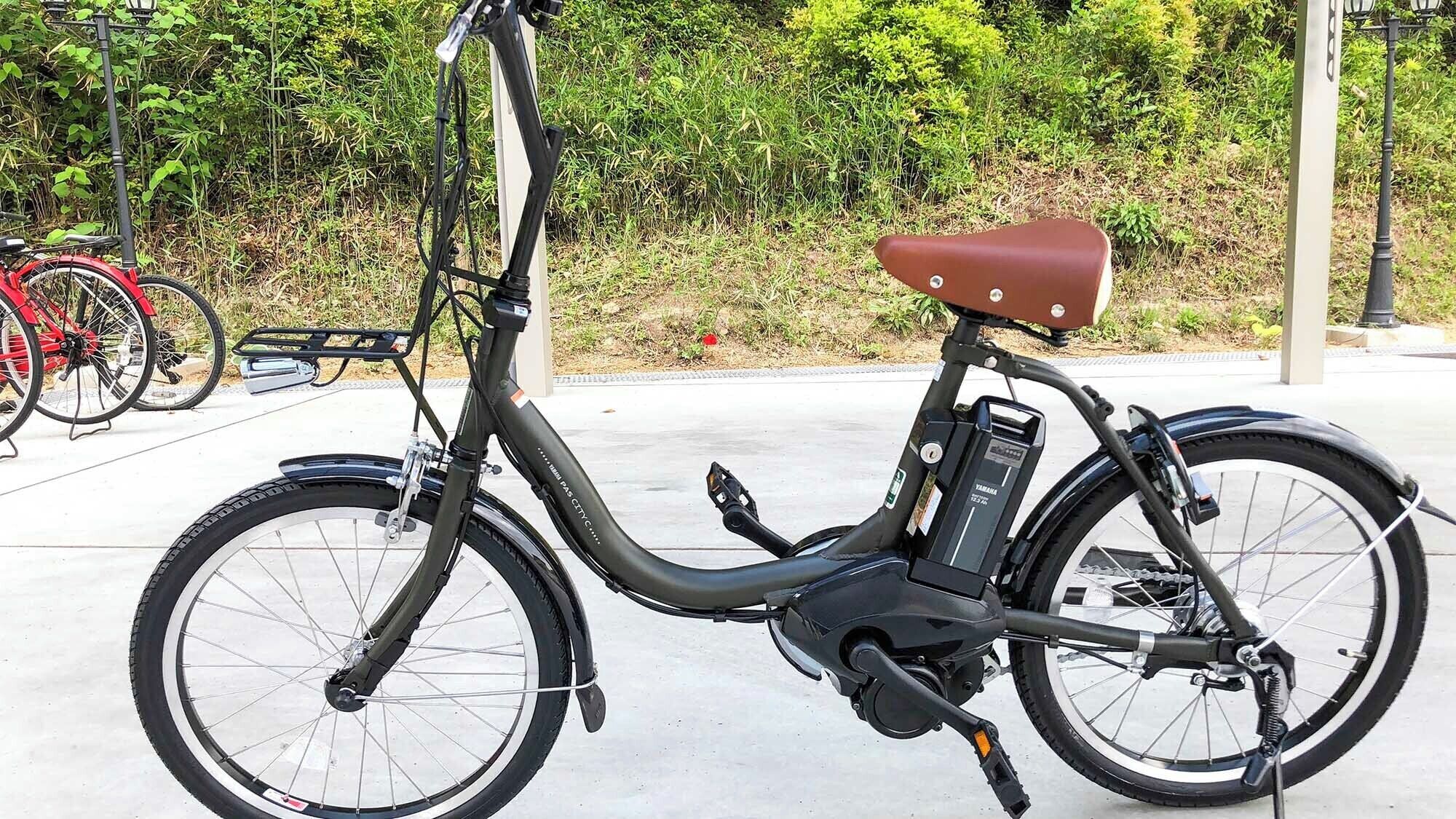 Ein feststehendes E-Bike mit braunem Sattel, schwarzem Rahmen und Akku am Hinterrad.