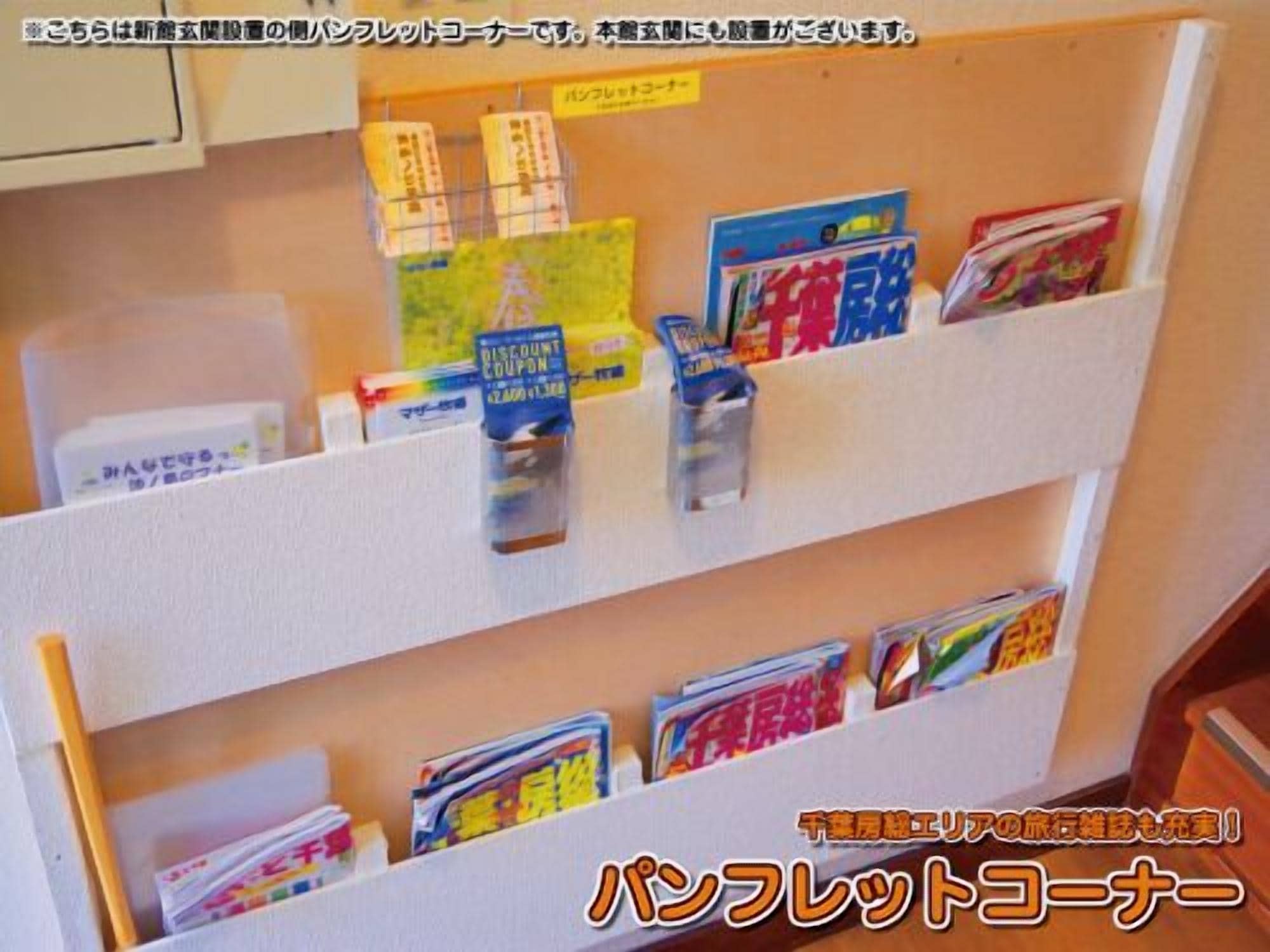 A bulletin board with various items pinned to it, including books, pamphlets, and a discount coupon.
