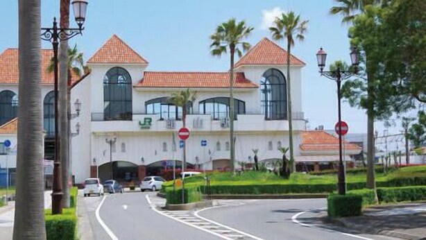 A large building with a white facade, multiple arched windows, and a red-tiled roof. - Maruhei Minshuku (Tateyama)