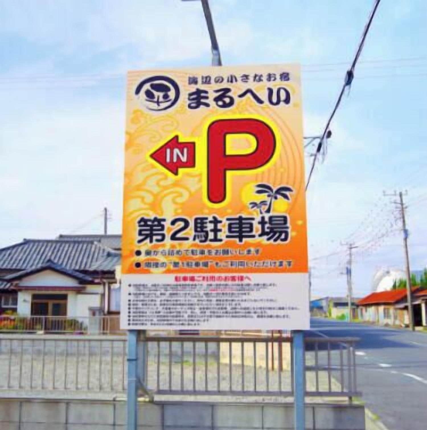 A parking sign with Japanese text and a large red 'P' indicating a parking area.
