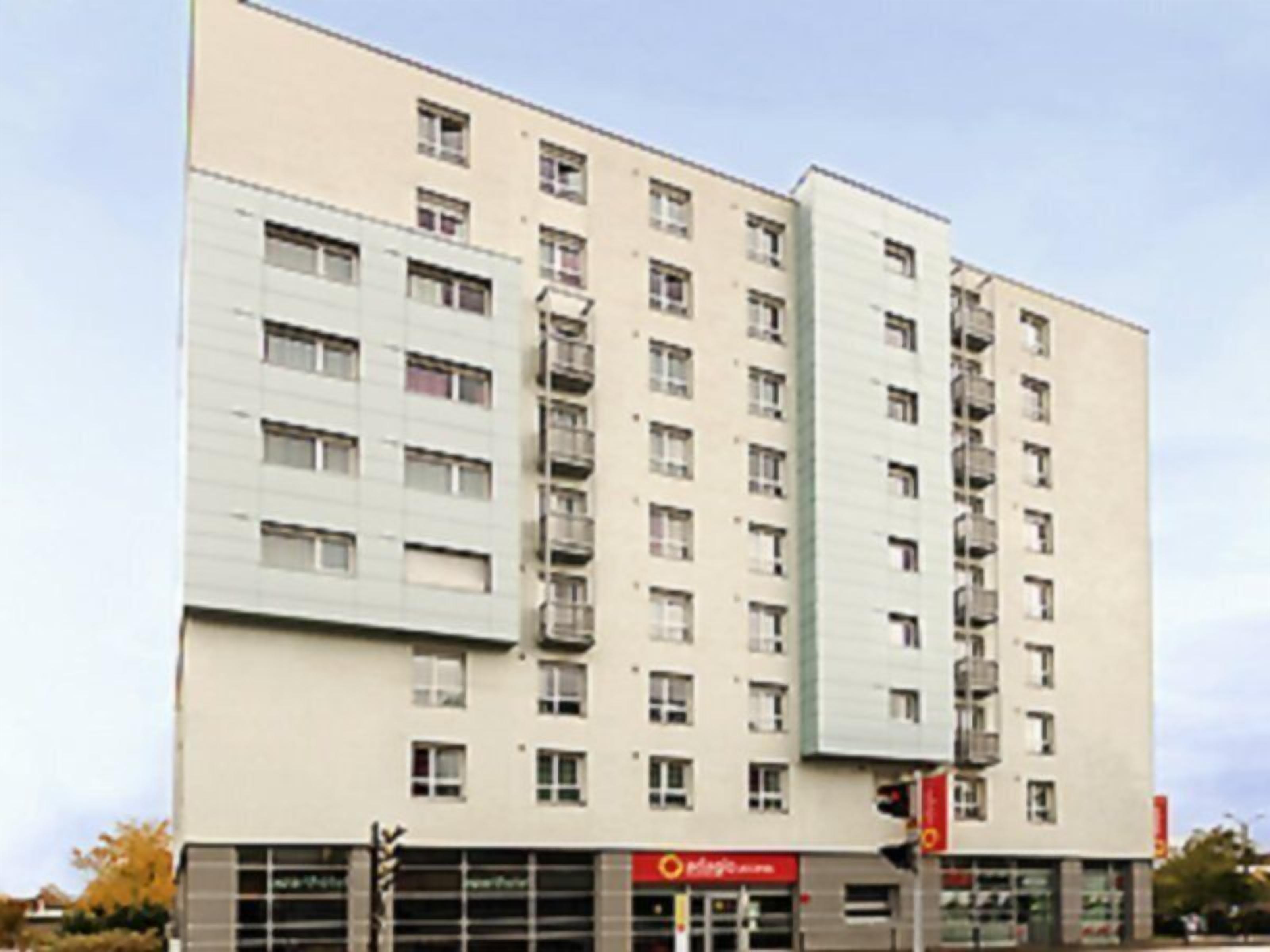 A multi-story building with a flat facade, large windows, and a visible storefront at the ground level.
