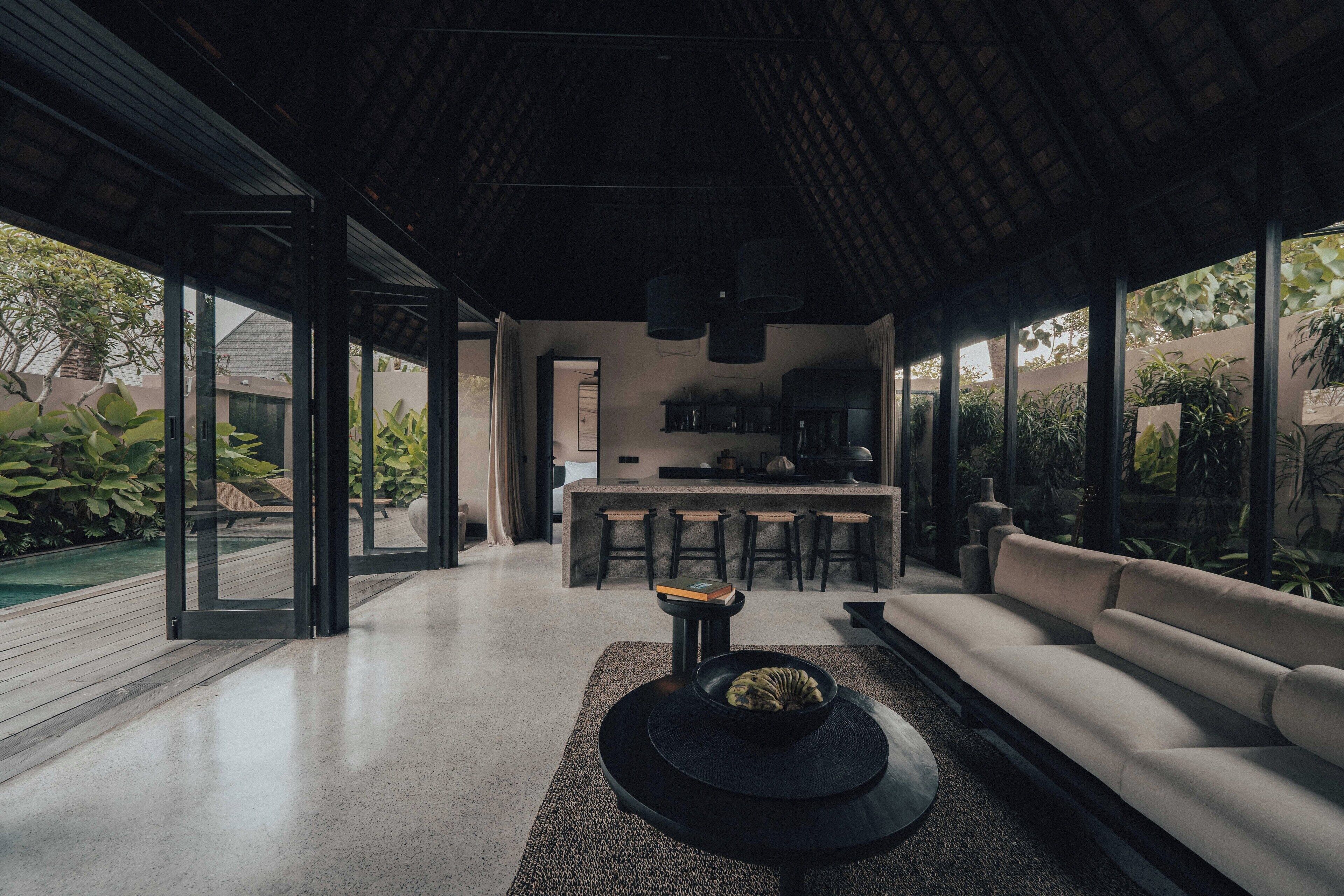 A modern interior with a sofa, a dining area, and a kitchen.