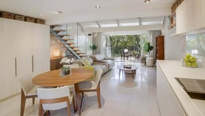 Cozinha moderna com área de refeições, escada e vista para o exterior.