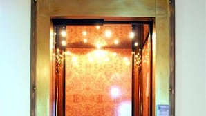 An elevator with a patterned wall and a control panel on the right side. - Hotel Ionas (Chania)