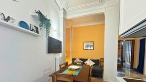 Un comedor con una mesa de madera, sillas, una mesa de buffet y un sofá.