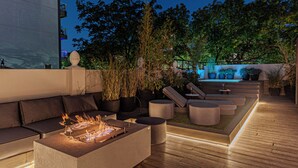 A rooftop terrace with a fire feature, seating areas, and potted plants. - Ultra Luxurious 3-bedroomHouse with Private Rooftop, Jacuzzi, BBQ area & Office (Buenos Aires)