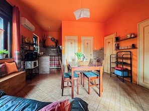 Un espace de vie compact comprenant une cuisine, un coin repas et un petit coin salon.