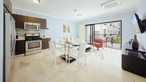 Una cucina moderna con zona pranzo, un'ampia finestra e una televisione a schermo piatto.