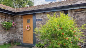 A stone building with a wooden door labeled "Cawsand." - Cawsand Cottage in Cornwall (Saltash)