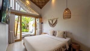 A spacious bedroom with a large bed, a hanging light fixture, and a view of the outdoors. - Sunset Bamboo by Pertama Stay (Kerobokan)