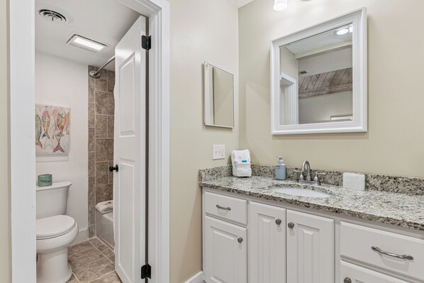 A bathroom with a toilet, sink, mirror, and cabinets. - NEW LISTING! Sea Palms Golf Course Home | 3BR St. Simons Island Vacation Rental (Saint Simons Island)