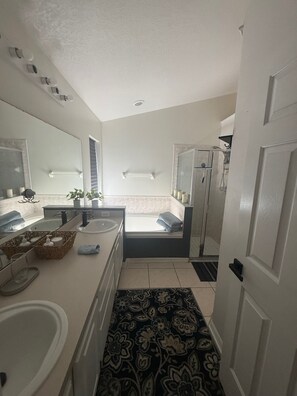 A bathroom with a bathtub, a shower, a sink, and a mirror. There is a door on the right side. - Comfy 2B/2b Near JW Marriott & Ritz, SeaWorld, Disney & Shops. Super Location (Orlando)