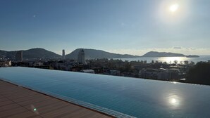 En takpool som ser ut att gå över kanten, med utsikt över en stad och berg.