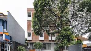 A modern building with a flat roof, large windows, and a mix of wood and concrete materials.