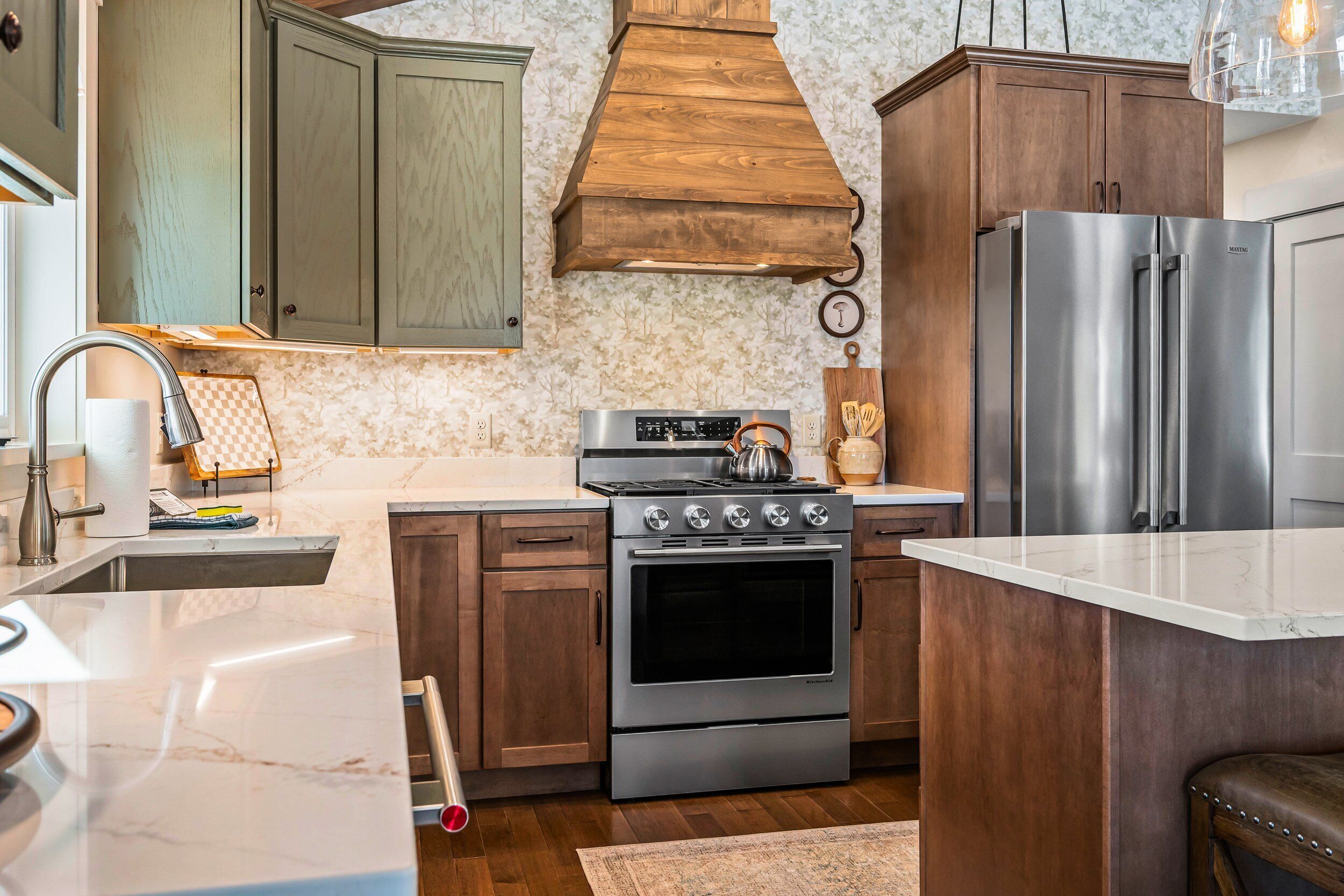 Une cuisine avec des meubles en bois, une cuisinière en acier inoxydable et un réfrigérateur.