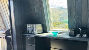 A modern kitchen with a built-in stove, a microwave, and a window overlooking a scenic landscape. - Blue Moon Apartment-Epic Mountain views Wanaka. (Wānaka)