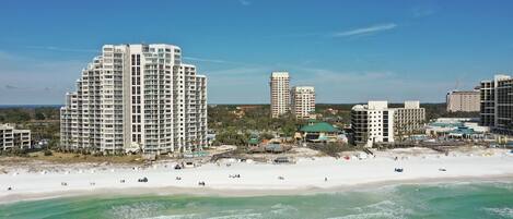 A coastal cityscape with high-rise buildings, a sandy beach, and ocean views.