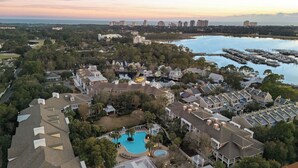 A residential area with a large swimming pool, a marina, and a view of the city skyline.