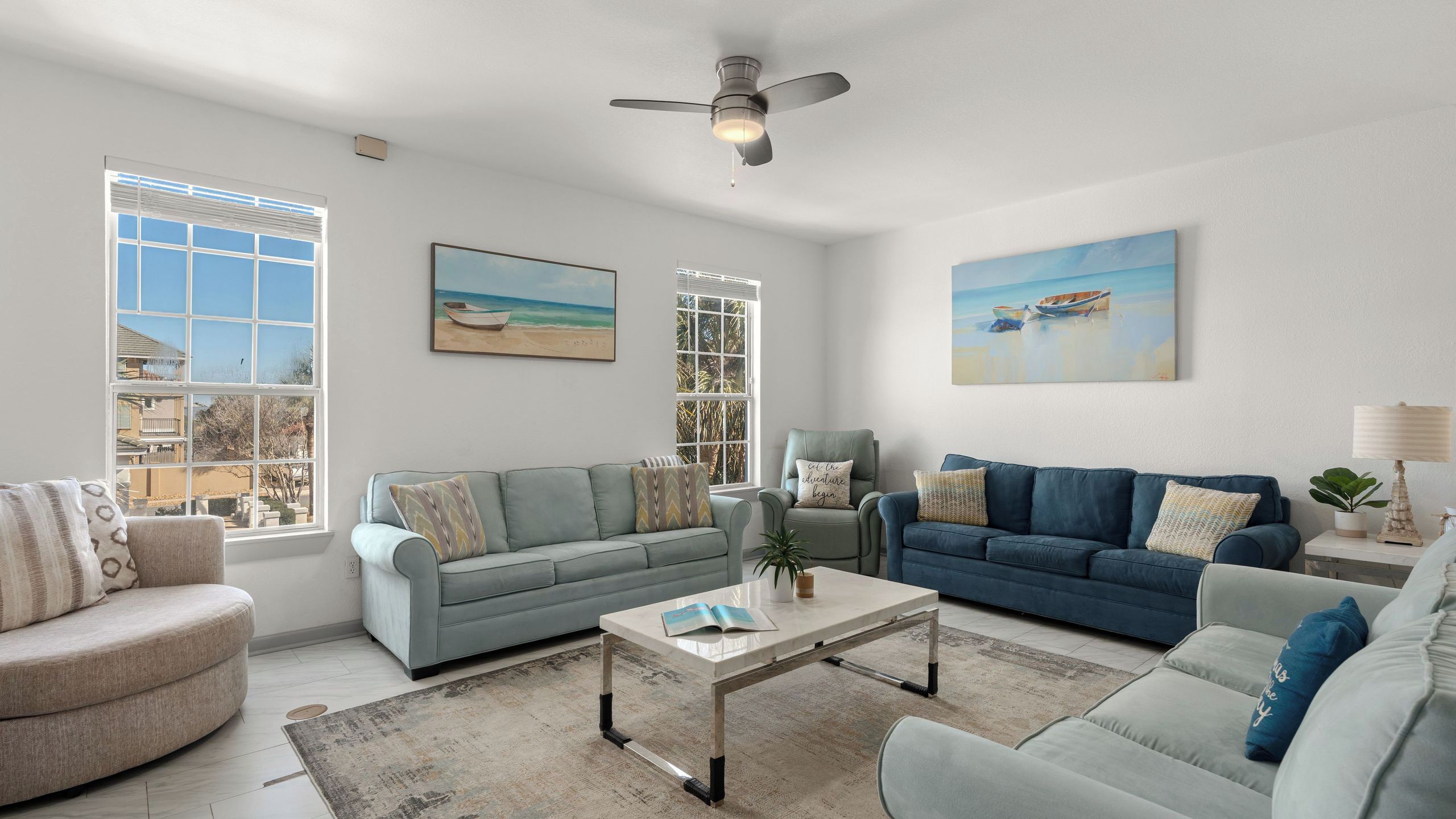 A living room with two sofas, a coffee table, and a ceiling fan.