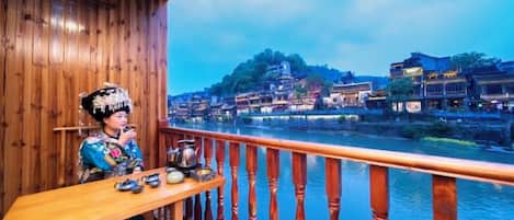 Un balcón de madera con vistas a un río y edificios tradicionales.