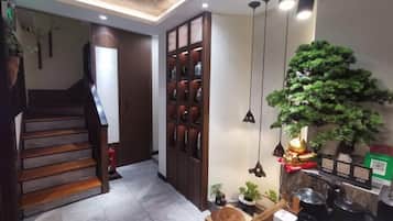 Una escalera que lleva a una plataforma, un mueble de madera con adornos y una planta en maceta.