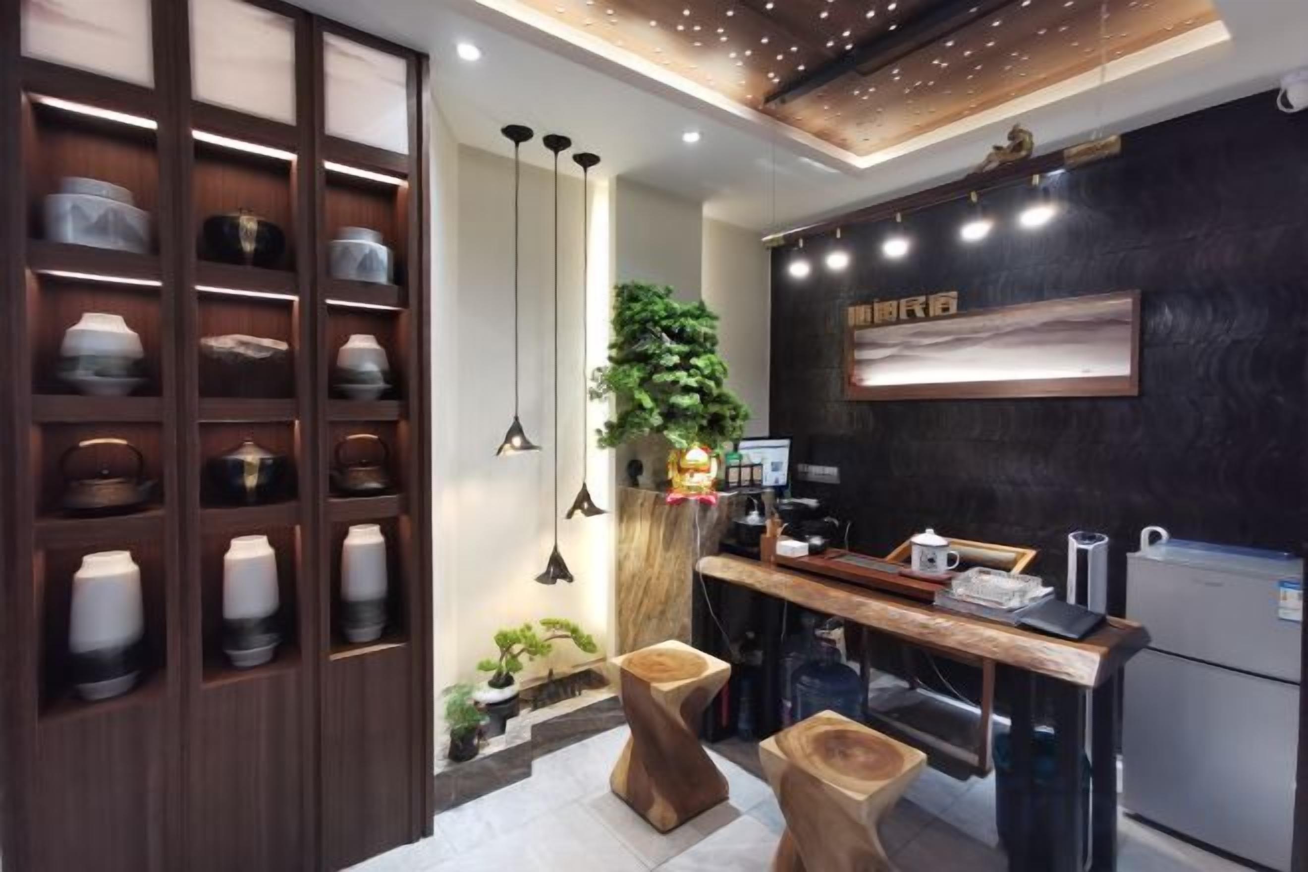 Una cocina moderna con armarios de madera, iluminación colgante y un salpicadero negro.
