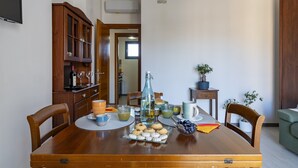 Una mesa de comedor dispuesta con varios objetos, incluyendo una botella, vasos y un plato de galletas.