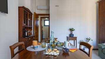 A dining table set with various items including a bottle, glasses, and a plate of cookies.
