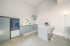 Een moderne keuken met een magnetron, een spoelbak en een raam.