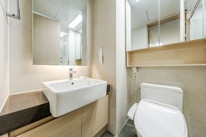 A modern bathroom with a white sink, wooden vanity, and a toilet. - Yangyang Oceanstay 24K (Yangyang)