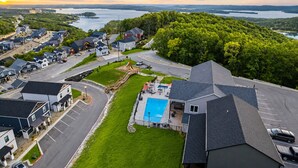 A residential area with houses, a swimming pool, and a view of a lake. - 9BR Table Rock Lake Lodge w/ Hot Tub & Game Room • Near SDC (Branson)